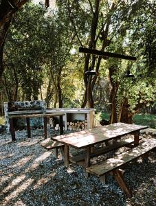 a picnic table and bench in a park with trees at Villa Vadori Suites in Falda del Carmen