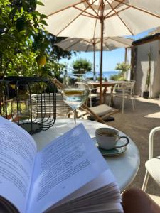 an open book on a table with a glass of wine at Sunshine Residence in Stara Baška