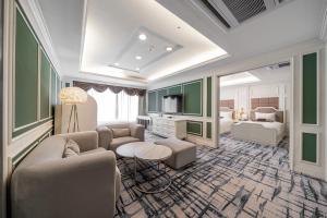 ein Wohnzimmer mit einer Couch und ein Zimmer mit einem Bett in der Unterkunft Koreana Hotel in Seoul