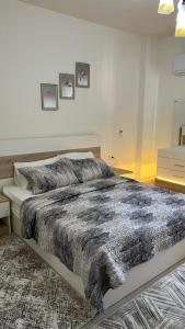 a bedroom with a large bed with a blanket on it at Laserina North Coast in Zāwiyat ‘Abd al Mun‘im