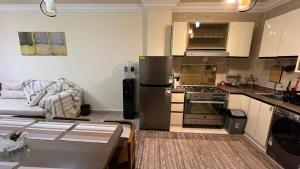 a kitchen with a stainless steel refrigerator and a couch at Laserina North Coast in Zāwiyat ‘Abd al Mun‘im