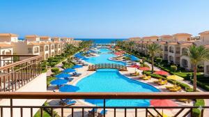 a view of a resort pool with chairs and umbrellas at Laserina North Coast in Zāwiyat ‘Abd al Mun‘im