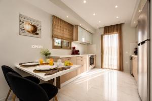 a kitchen with a table with plates and oranges on it at Efilenia Luxury Villas in Corfu