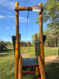a wooden swing in a park at Flat Hotel Canarius Gravatá in Gravatá