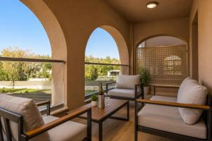 a living room with arched windows and a table and chairs at Efilenia Luxury Villas in Corfu