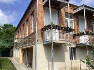 a brick building with two balconies with flowers on them at B&B Villa Maurizio in Tsqaltubo