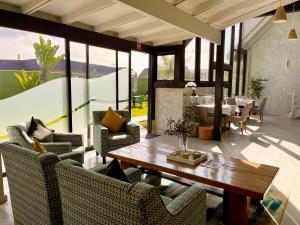 a living room with chairs and a wooden table at Olive Tree Boutique Guesthouse in Swakopmund