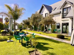 a yard with a table and chairs and a house at Olive Tree Boutique Guesthouse in Swakopmund