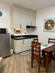 a kitchen and dining room with a table and a refrigerator at Antara Residences - 1BR in Talisay
