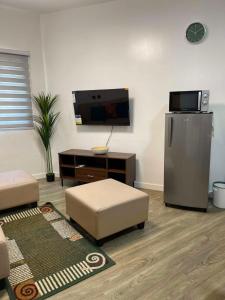 a living room with a refrigerator and a tv at Antara Residences - 1BR in Talisay