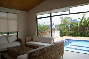 a living room with a view of a swimming pool at Prima verde in La Serena
