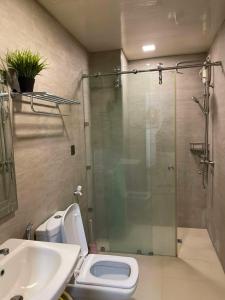 a bathroom with a shower and a toilet and a sink at Antara Residences - 1BR in Talisay