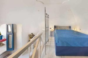 a bedroom with a blue bed and a staircase at The Sirens House in Nerano