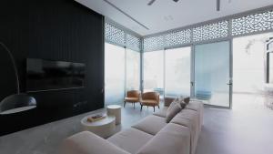 a living room with a white couch and a large window at Villa Vibes Eilat Villa 26 - 8 bedrooms with private pool in Eilat