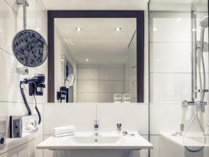 a bathroom with a sink and a mirror at Fürther Hotel Mercure Nürnberg West in Fürth