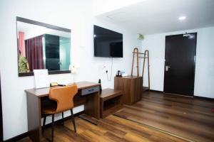 a room with a desk with a chair and a mirror at Prince Hotel in Tawau +41 photos