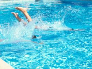 a person laying on their back in a swimming pool at Novotel Nürnberg am Messezentrum in Nuremberg