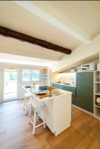a kitchen with a white island with stools at Relais Lungolago Gavirate in Gavirate +17 photos