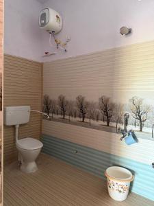 a bathroom with a toilet and a window with trees at Sagara Darshanam in Vetāpālem