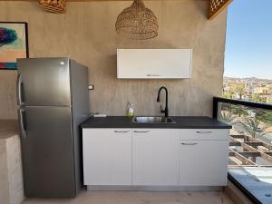 a kitchen with a stainless steel refrigerator and a sink at Kohav Sea View Penthouse in Eilat