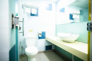 a bathroom with a white toilet and a sink at Prince Hotel in Tawau