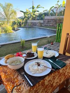 a table with plates of food and drinks on it at Villa Baby lodge in Hell-Ville