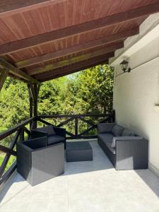 a patio with couches and a wooden roof at Domek letniskowy Wielonek 4 in Cierplewo