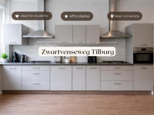a white kitchen with white cabinets and appliances at Nature Stay near Tilburg Uni & Center in Tilburg