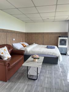 a room with a bed and a couch and a table at ไร่ปราณปรียา in Campson +18 photos