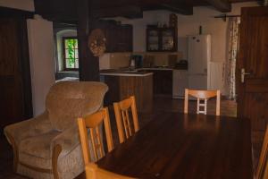 a kitchen with a wooden table and chairs and a dining room at Statek VRANČ - U Kačenky in Bítov