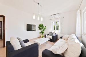 a living room with two couches and a tv at APARTMENT MARCELA SUTIVAN - large two-bedroom apartment with two bathrooms - excellent location right by the town center and the beach - parking space provided - panoramic view of the sea and the town in Sutivan