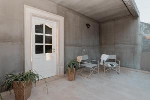 a patio with chairs and a table and a door at APARTMENT MARCELA SUTIVAN - large two-bedroom apartment with two bathrooms - excellent location right by the town center and the beach - parking space provided - panoramic view of the sea and the town in Sutivan