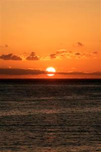 a sunset over the ocean with the sun setting at Hotel Gran Rey in Valle Gran Rey