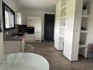 a kitchen with white cabinets and a glass table at Chaudeney in Chaudeney-sur-Moselle