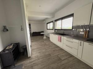 a kitchen with white cabinets and a living room at Chaudeney in Chaudeney-sur-Moselle +1 photo