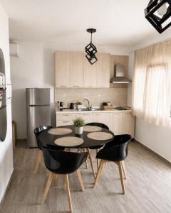 a kitchen with a table and chairs and a refrigerator at Vigla summer house! in Paralia Sikias +4 photos