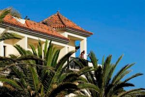 a man standing on a balcony of a building at Hotel Gran Rey in Valle Gran Rey