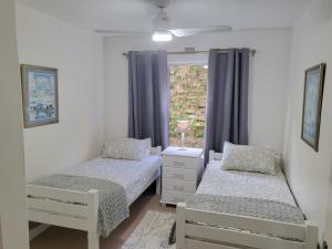 two beds in a room with a window at Ramsgate Palms 3 in Ramsgate