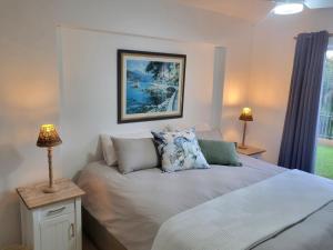 a bedroom with a bed and two lamps and a window at Ramsgate Palms 3 in Ramsgate