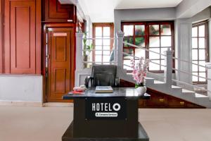 a hotel reception desk in a lobby with stairs at Hotel O Ghoom Formerly Aps Homestay in Darjeeling