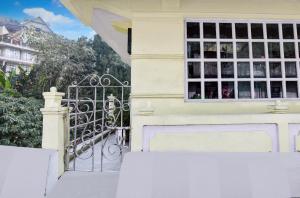a white house with a gate and a window at Hotel O Ghoom Formerly Aps Homestay in Darjeeling