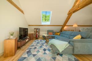 a living room with a blue couch and a tv at La maison des jours heureux in Leysse