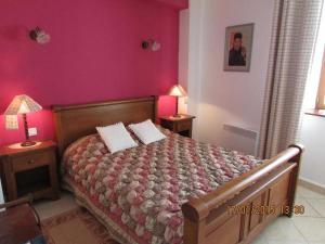 a bedroom with a bed with pink walls at Montmajou in Cier-de-Luchon