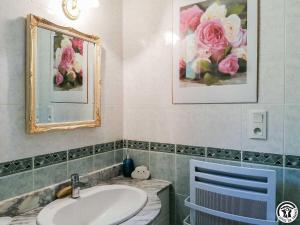 a bathroom with a sink and a mirror and flowers at Montmajou in Cier-de-Luchon +21 photos