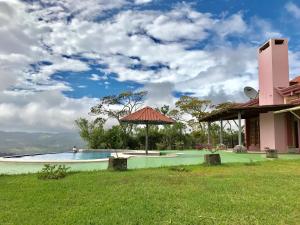uma piscina com um guarda-sol ao lado de uma casa em Dream Villa, Ocean View & Pool! em San Ramón