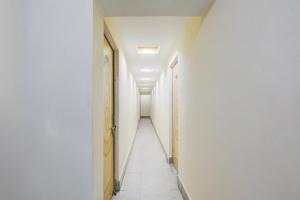a hallway with white walls and a long corridor at Super Hotel O Anjanpeer Post Office Hajipur Formerly Hotel New Urvashi in Hājīpur