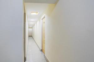 a hallway with a white wall and a door at Super Hotel O Anjanpeer Post Office Hajipur Formerly Hotel New Urvashi in Hājīpur +25 photos