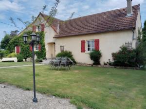 a house with a table and chairs in the yard at Les Chambres D'Anel in Saint-Pourçain-sur-Besbre