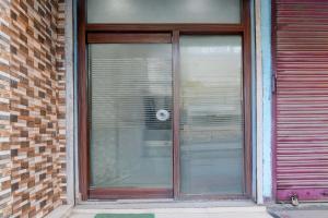 a glass door of a building with a window at Hotel O Kanchenjunga Stadium Formerly Bindhan's Inn in Siliguri