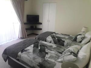 a bedroom with a bed and a television in a room at 17 Villa Leadwood in Jeffreys Bay